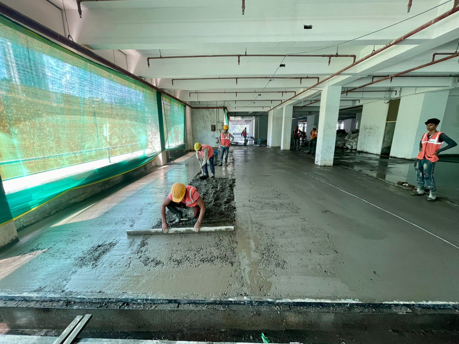 Screed being levelled over a concrete base floor